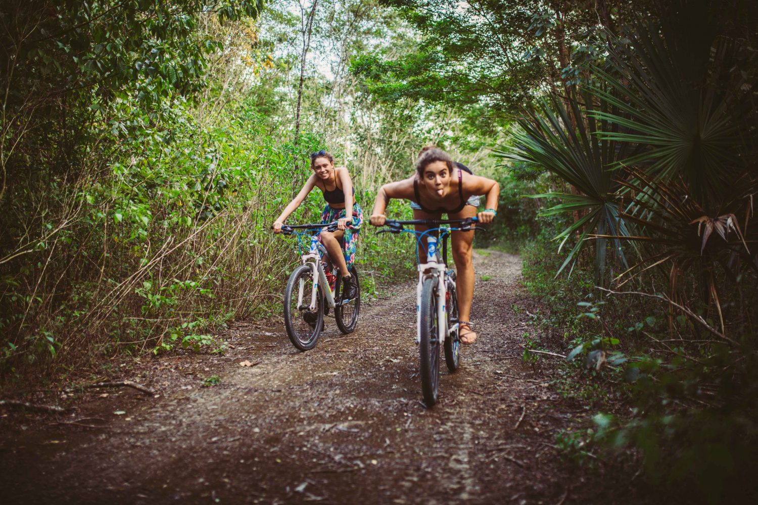Zwei junge Frauen mit Fahrrad im Dschungel
