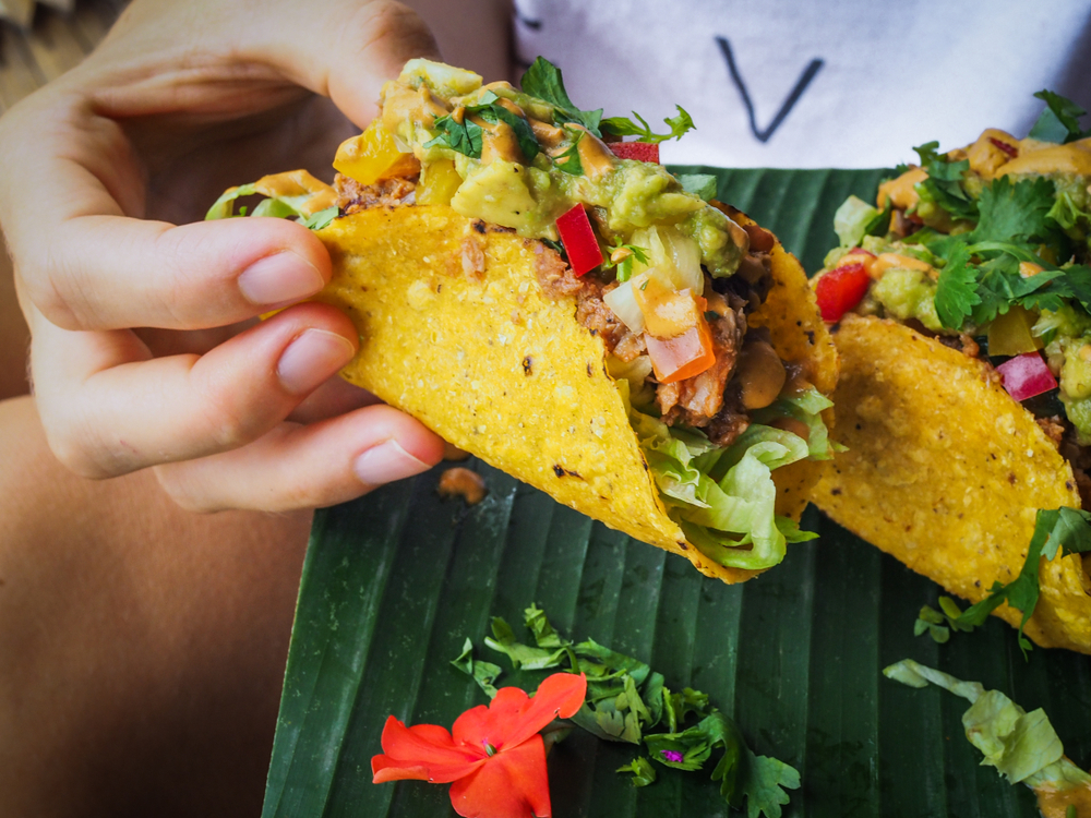 Frau hält vegane Tacos in der Hand